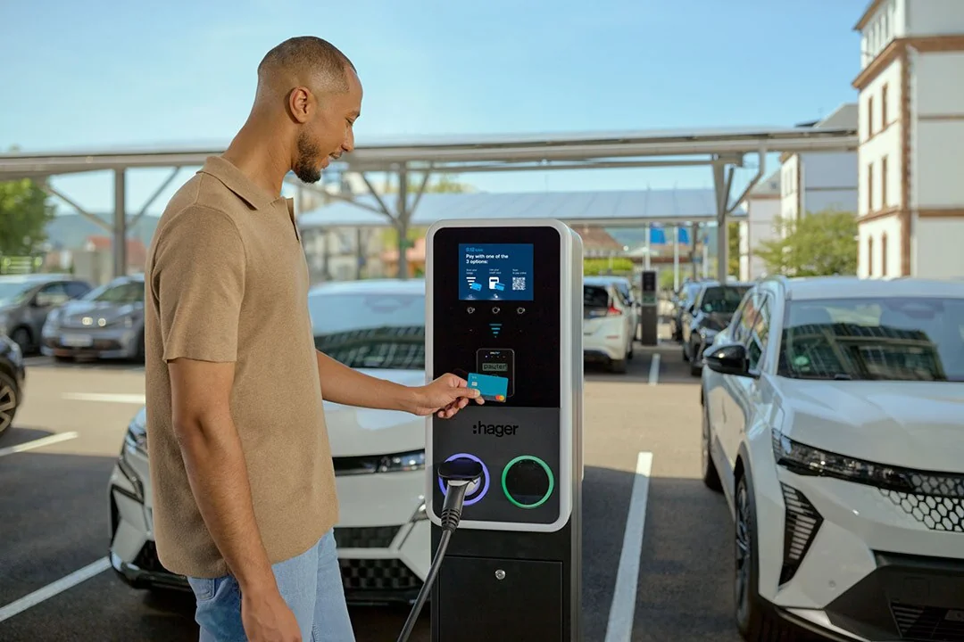 Un conducteur utilise l’écran d’une borne Hager witty park 2 sur un parking
