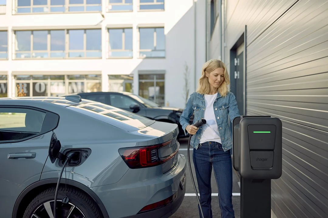 Une utilisatrice recharge son véhicule avec une Hager witty pro sur un parking