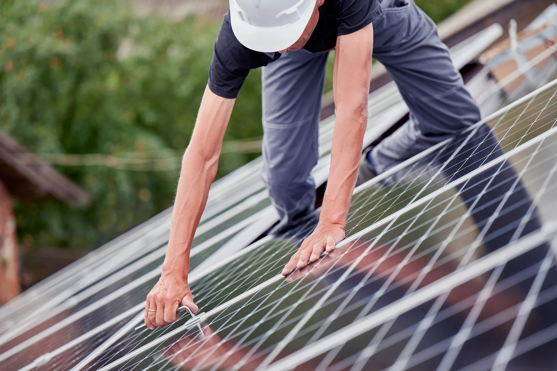 Un installateur ajuste un panneau photovoltaïque sur une toiture