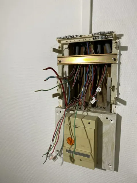 Ancien tableau ouvert avec des fils apparents pendant les travaux électriques