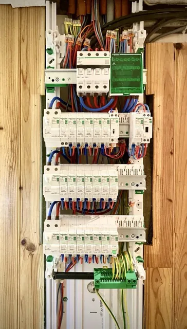 Intérieur d’un tableau électrique avec ses disjoncteurs et ses bornes de terre