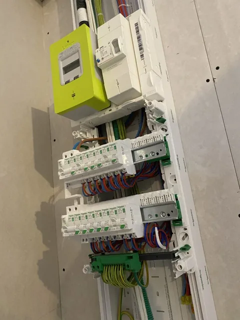 Vue de côté d’un compteur Linky et d’un tableau ouvert avec leurs conduits