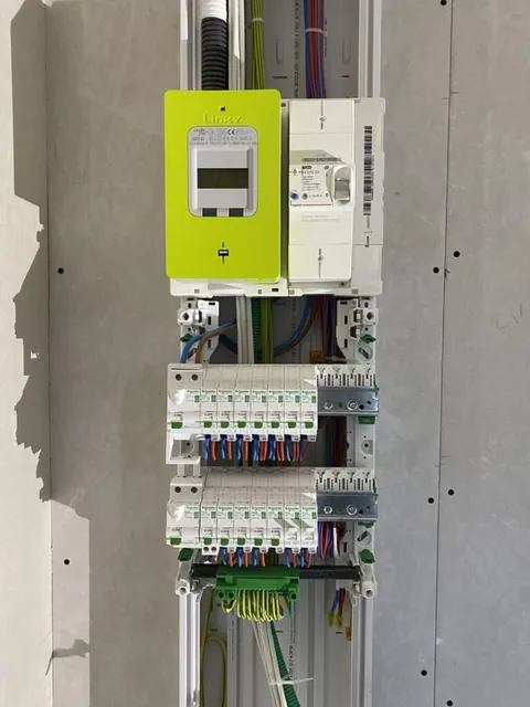 Vue de face d’un tableau électrique ouvert sous un compteur Linky