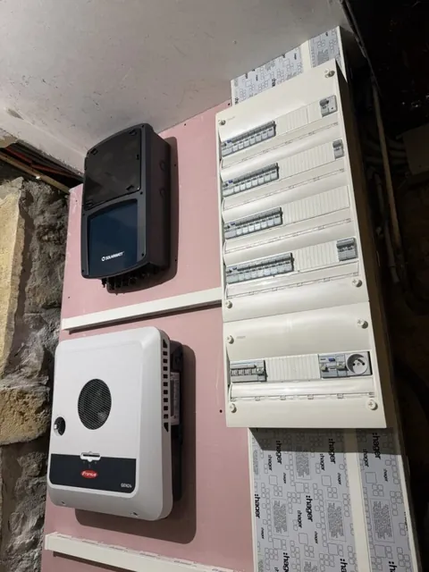 Équipements de conversion et tableau électrique sur un mur de couleur rose