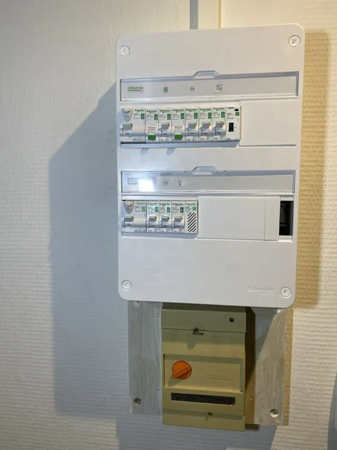 Tableau électrique fermé avec ses rangées de protections et un sectionneur jaune