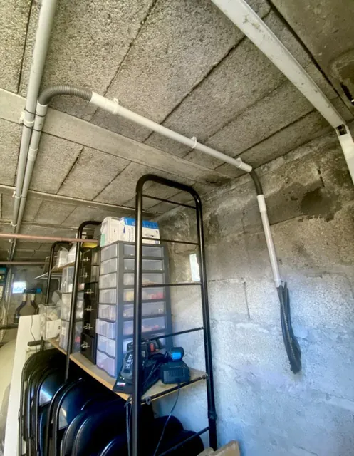 Cheminement des conduits de recharge au plafond d’un garage en cours d’installation