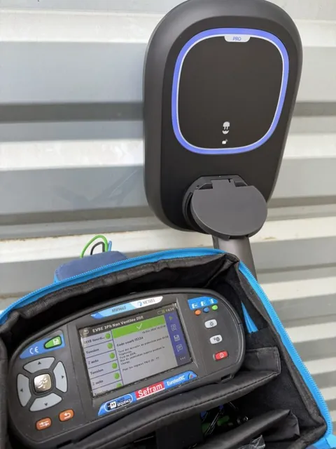 Appareil de test raccordé à une borne de recharge au voyant bleu