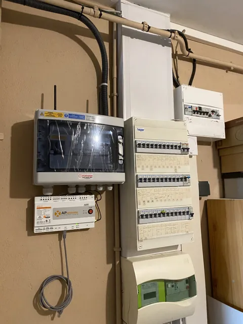 Coffrets de protection et compteur Linky fixés sur un panneau en bois
