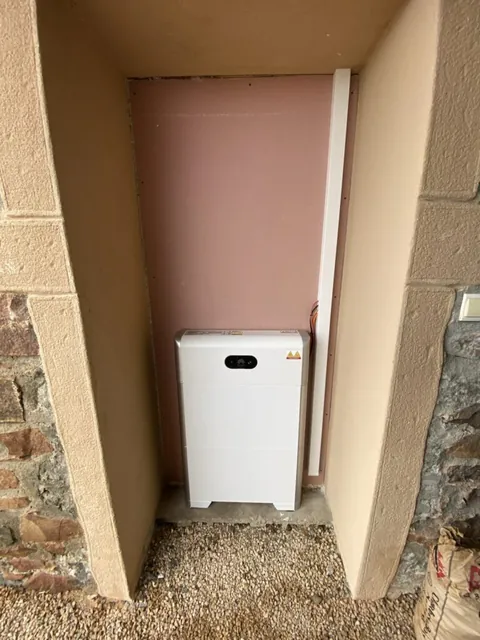 Équipement solaire blanc installé contre un mur entre deux montants en bois