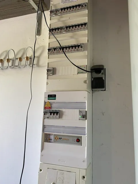 Coffrets et câblage électrique d’une installation solaire sur un mur brut