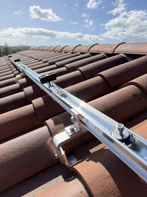 Détail des rails et des fixations photovoltaïques sur les tuiles