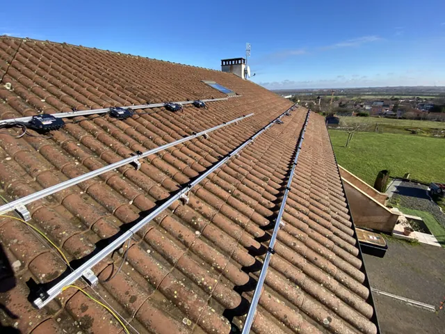Micro-onduleurs noirs fixés sur les rails avant la pose des panneaux solaires