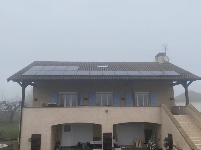 Maison équipée de panneaux solaires vue de loin par temps brumeux